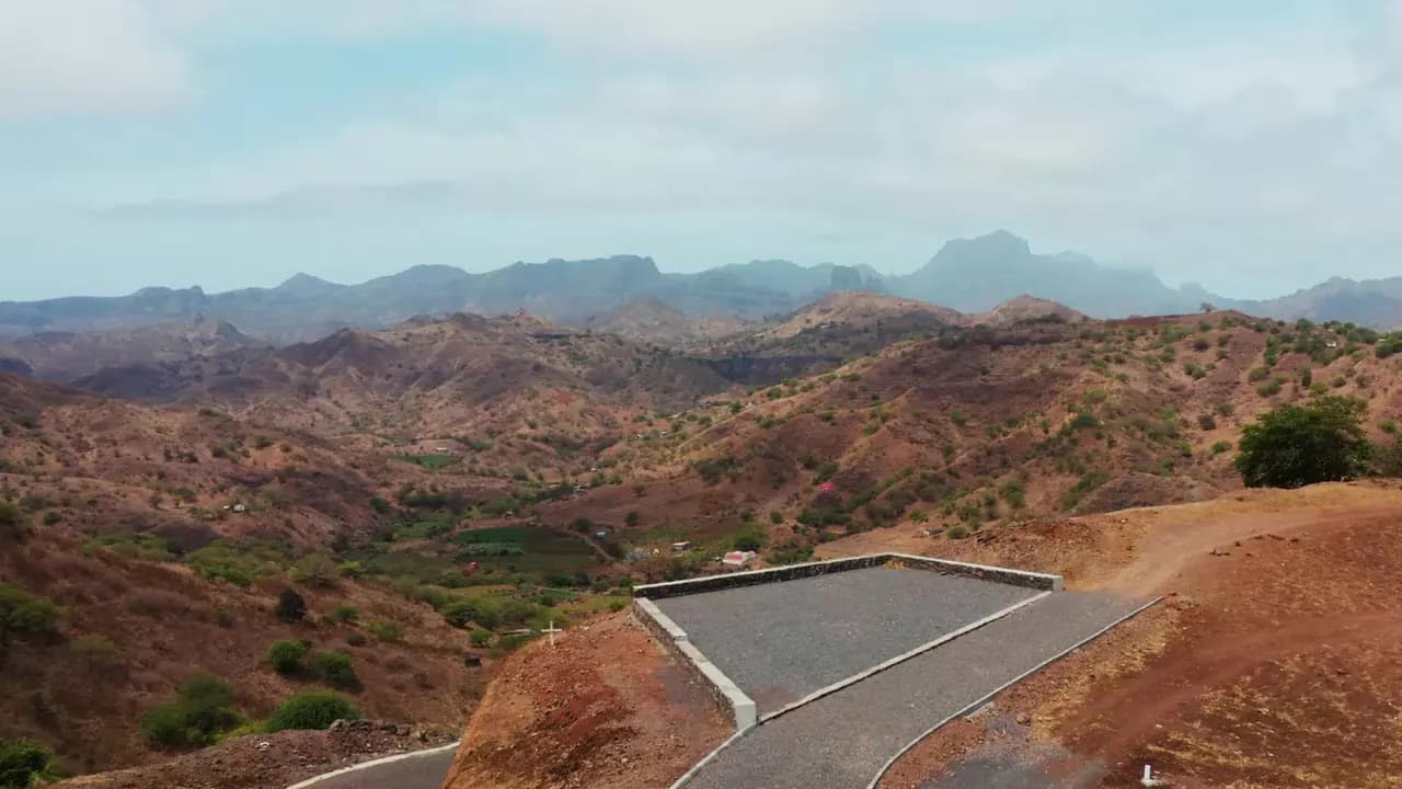 Vista aérea de uma estrada requalificada entre montanhas e terreno rural